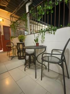 a patio with two tables and chairs and plants at YY Residences in Ipoh