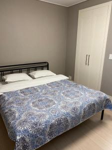 1 dormitorio con 1 cama con edredón azul y blanco en ЖК Highvill Ishim D1, en Astana