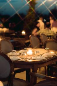 a wooden table with glasses and candles on it at 193 Urban Hotel in Patra