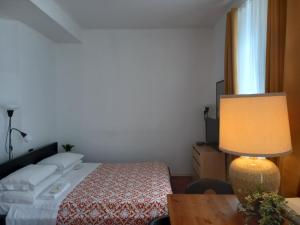 a bedroom with a bed and a lamp at with Free secure Parking garage - Home Suite Sweet Home - zone Duomo Montenapoleone - con parcheggio incluso - with free guarded parking garage - Luxury Fashion district - subway San Babila in Milan