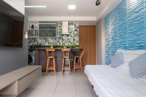 uma sala de estar com uma cama e uma cozinha em vemproCUPEPORTODEGALINHAS Casal ou Família no melhor apartamento de Porto de Galinhas em Porto de Galinhas