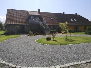 a house with a gravel driveway in front of it at Ferienwohnungen Familie Jahn in Thesenvitz