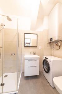 a bathroom with a washing machine and a sink at Deštné apartmány in Deštné v Orlických horách