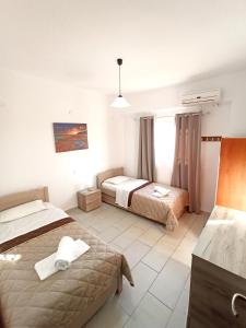 Habitación de hotel con 2 camas y ventana en Villa Pouliezos Apartments, en Alikanas