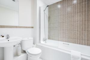 ein weißes Badezimmer mit Toilette und Waschbecken in der Unterkunft Roomspace Serviced Apartments - Royal Swan Quarter in Leatherhead
