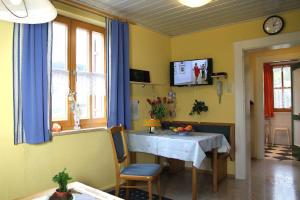 ein Esszimmer mit einem Tisch und einem TV an der Wand in der Unterkunft Landhaus Panorama in Bayerisch Eisenstein