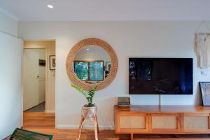 a living room with a mirror and a wooden table at Tropical Boho Nightcliff Casinha 3BR 1.5BR in Nightcliff