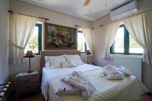 1 dormitorio con 1 cama con toallas en Villa Irene: Θέα πισίνα, Θέα θάλασσα en Áyioi