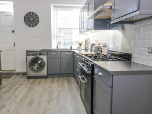 een keuken met een fornuis en een wasmachine bij The Lazy Seal in Berwick-Upon-Tweed