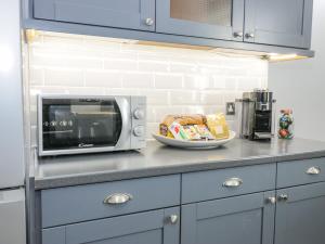 encimera de cocina con microondas y plato de comida en The Lazy Seal en Berwick-Upon-Tweed