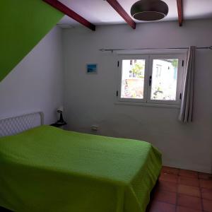 a bedroom with a green bed and a window at Vista del Sur in Alajeró