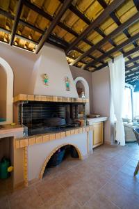 una cocina con chimenea en una casa en Villa Irene: Θέα πισίνα, Θέα θάλασσα en Áyioi