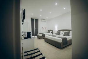 Cette chambre comprend deux lits et une télévision. dans l'établissement Dimora Fantasia Charme B&B, à Bari