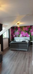 1 Schlafzimmer mit 2 Betten und einer Blumenwand in der Unterkunft Landhaus Eifelsicht in Hellenthal
