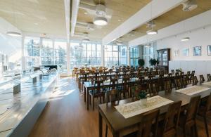 a dining room with tables and chairs and windows at Etelä-Pohjanmaan Opisto in Ilmajoki