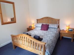 a bedroom with a bed with two night stands and a mirror at Cosy Cottage In Cardigan in Cardigan