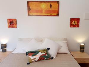 ラ・カレッタにあるLa Rosa dei Ventiの白い枕と壁画付きのベッド