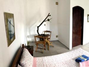 a bedroom with a bed and a chair and a table at Pousada Atelier Aly da Costa in Iguape