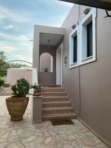 ÁyioiにあるVilla Irene: Θέα πισίνα, Θέα θάλασσαの植物のある家に通じる階段