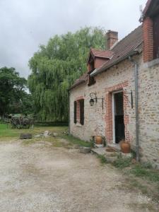 un viejo edificio de ladrillo con dos ollas delante en L'auberge 10 à 15 pers 30min zoo beauval chambord cheverny en Langon