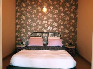 sypialnia z łóżkiem i tapetą w kwiaty w obiekcie Ático encantador... w mieście A Coruña