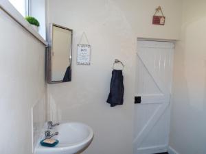 une salle de bain avec un lavabo et un miroir dans l'établissement Cosy Cottage In Cardigan, à Cardigan 6 autres photos