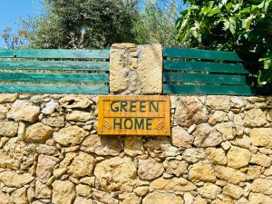 un cartel que dice hogar verde en una pared de piedra en The Green Home, en Afráta