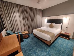 Habitación de hotel con cama y mesa en Chryso Hotels Pvt Ltd, en Ankleshwar