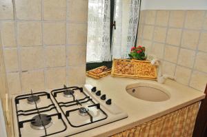 a kitchen counter with a stove and a sink at Trulli Vulés in Ostuni