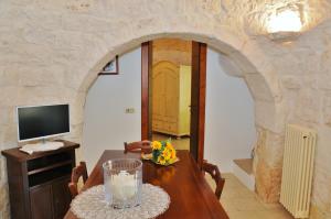 a dining room with a table with a vase of flowers at Trulli Vulés in Ostuni