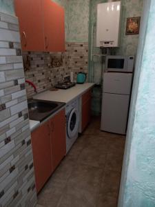 a kitchen with a stove and a sink and a dishwasher at 1 комнатная квартира в центре Мукачева, улица Мира in Mukacheve