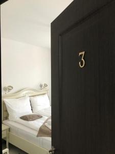 a black door with a bed in a room at Pensiunea ARMONIA in Văleni