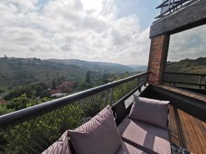 a balcony with pillows and a view of the mountains at Manor on the Hill in Krugersdorp
