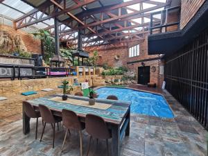 a patio with a table and a swimming pool at Manor on the Hill in Krugersdorp