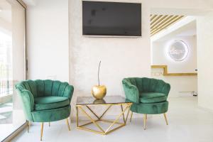 2 grüne Stühle und ein Couchtisch im Wohnzimmer in der Unterkunft Hotel Zonya in Sonnenstrand