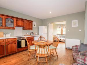 a kitchen and dining room with a table and chairs at Smithy Cottage in Achnasheen