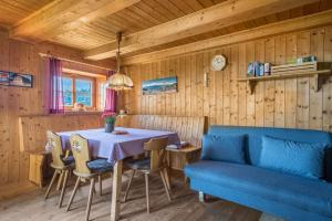 una sala da pranzo con tavolo e divano blu di Almhütte Jägerrast a Verano
