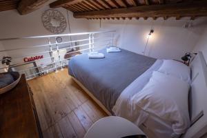 ein Schlafzimmer mit einem großen Bett mit weißer Bettwäsche in der Unterkunft Santa Fiora Ospitalità Diffusa - La Casa del Miccio in Santa Fiora