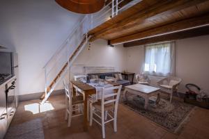 ein Esszimmer mit einem Tisch, Stühlen und einer Treppe in der Unterkunft Santa Fiora Ospitalità Diffusa - La Casa del Miccio in Santa Fiora
