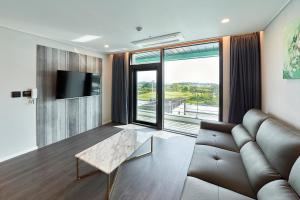 a living room with a couch and a tv at SN Hotel Daecheon in Boryeong