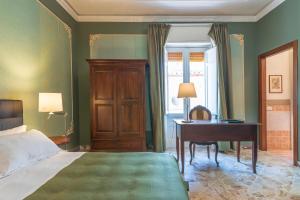 a bedroom with a bed and a desk and a bed sidx sidx sidx at Casa Neathon - Whole House 14 guest in Noto