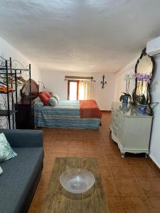 a living room with a bed and a couch at La Buhardilla de Torrecillas in El Bosque
