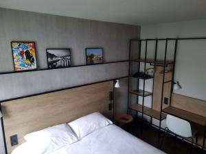 una camera con un letto e una mensola sopra di esso di ibis Bayonne Centre a Bayonne