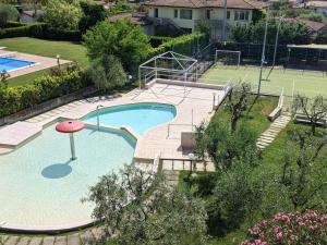 an overhead view of a swimming pool with a tennis court at Residence Primera in Moniga