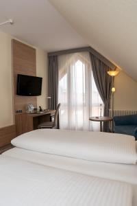 a hotel room with a bed and a television at Hotel Kastanienhof in Erding