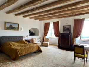 a bedroom with a bed and a desk and windows at Château du Puech in Curières