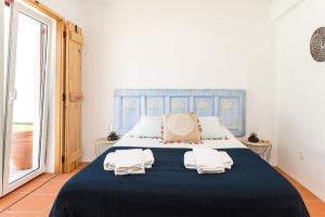 a bedroom with a large bed with two towels on it at Casa do Peladiço in Fataca