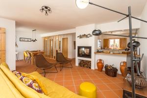a living room with a yellow couch and a kitchen at Casa do Peladiço in Fataca