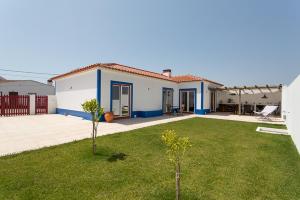 ein weißes und blaues Haus mit einem Hof in der Unterkunft Casa do Peladiço in Fataca