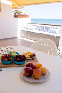 einen Tisch mit Obstteller und Gemüse darauf in der Unterkunft FLORIT FLATS - The Xeraco Beach Frontline Apartment in Xeraco